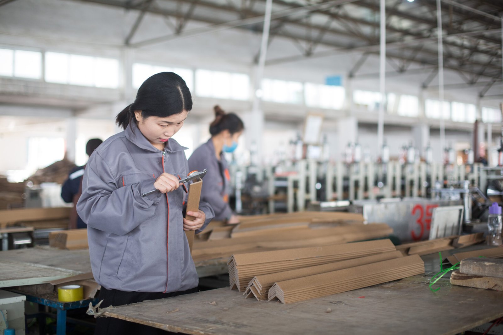 Hengnice team member inspecting paper edge protectors during production