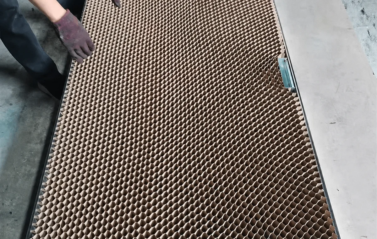 Worker preparing honeycomb paper core for door filling