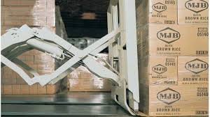 Forklift push-pull attachment handling a carton load on a slip sheet